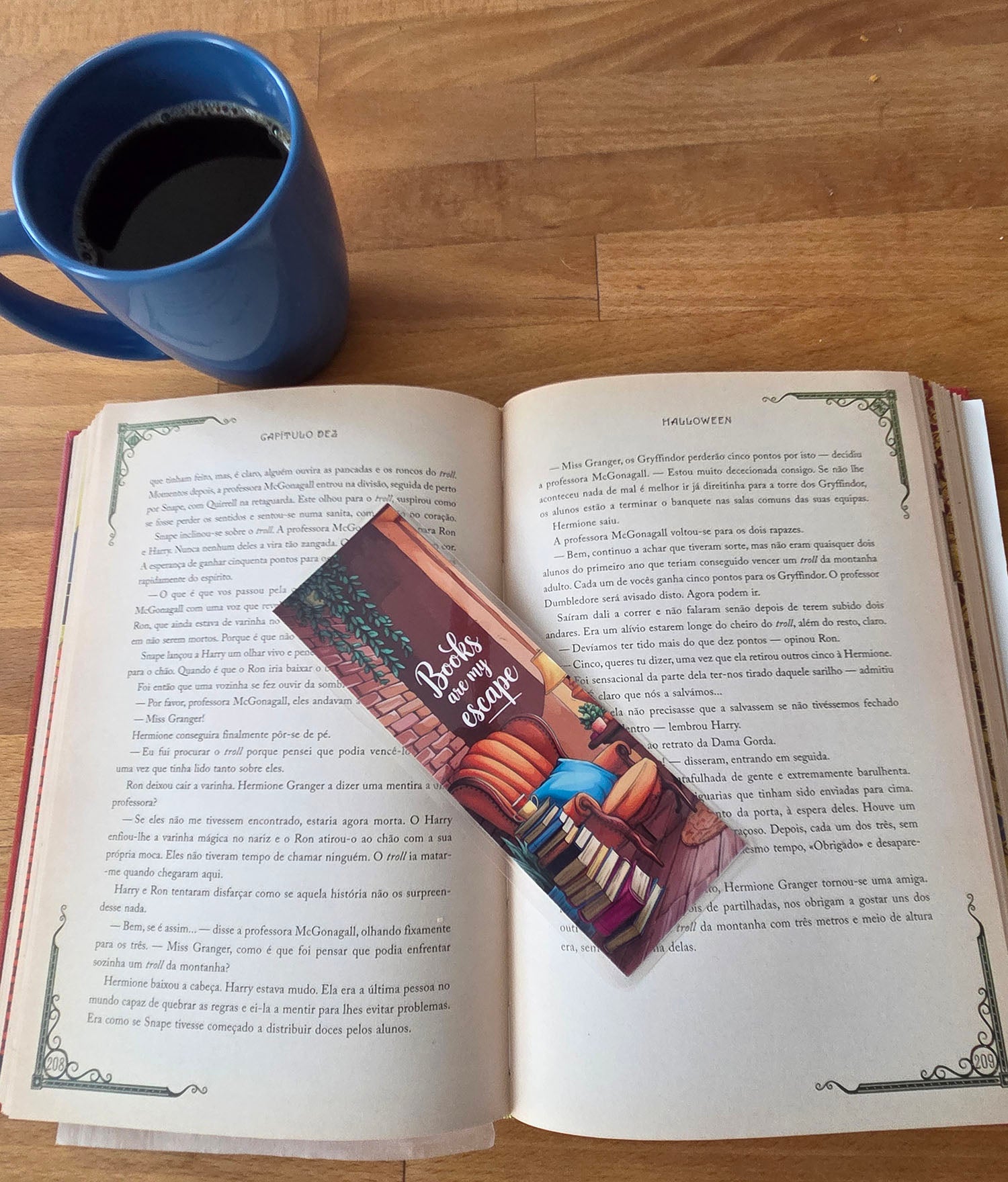 Open book with a bookmark featuring a sofa with a tecup on a stack of books 